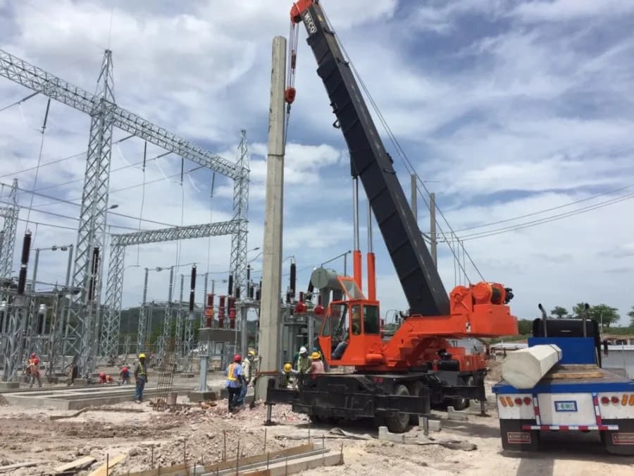 Crane installing poles at a substation